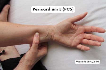 Hand position for PC5+6 pressure points on inner wrist for migraine and nausea relief.