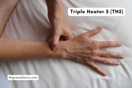 Triple Heater 5 hand position pressure point for migraine relief. Located above the outside wrist.